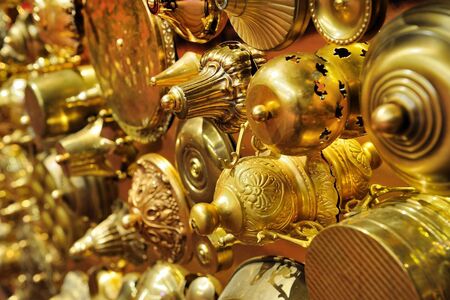 Close-up van een verscheidenheid aan gouden decoratieve objecten en elementen, met verschillende texturen en vormen.
