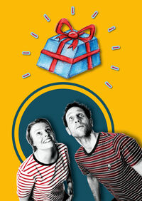 Twee mensen in gestreepte shirts kijken omhoog naar een ingepakt cadeau tegen een gele achtergrond.