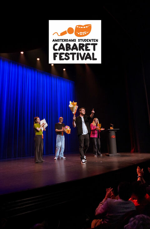 Een cabaretfestival met artiesten op het podium, gekleed in kleurrijke outfits, voor een blauwe achtergrond.