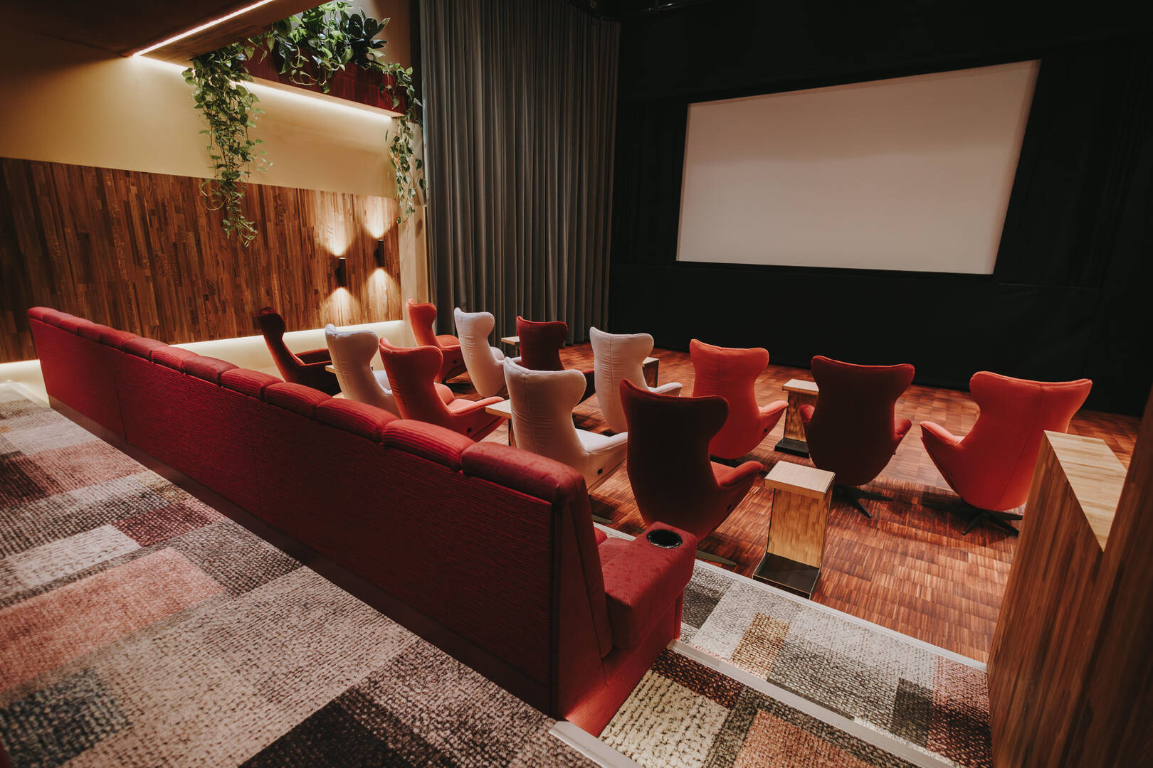 Interieur van een moderne thuisbioscoop met comfortabele stoelen en een groot projectiescherm.