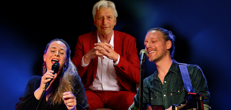 Zangeres en muzikanten op podium, met een man in een rode jas als centrale figuur.