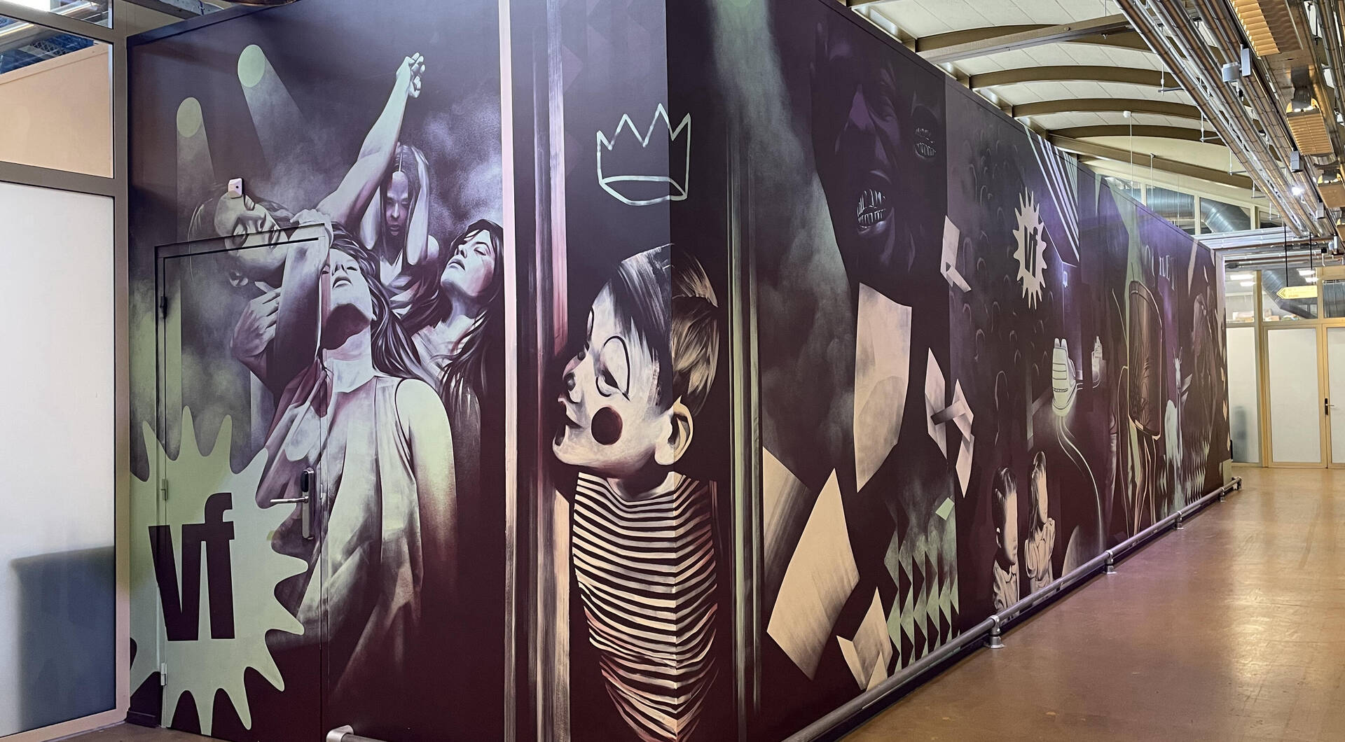 Muur met kleurrijke graffiti en afbeeldingen van mensen in actie, in een levendige evenementenruimte.