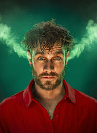 Portret van een man met een intense blik, omgeven door groene rook die uit zijn hoofd lijkt te komen.