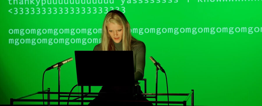 Vrouw zit achter een laptop voor een groene achtergrond met computercode.