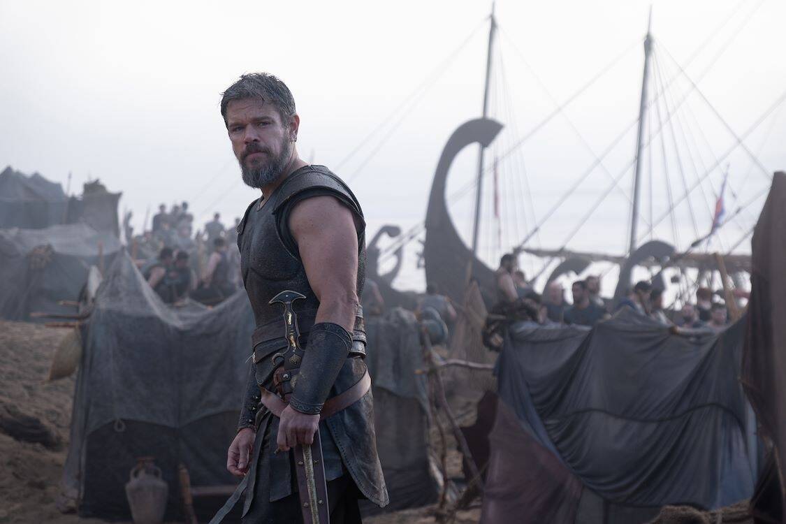 Russell Crowe als een krijger met een zwaard, omringd door vikingschepen op een mistige kustlijn.