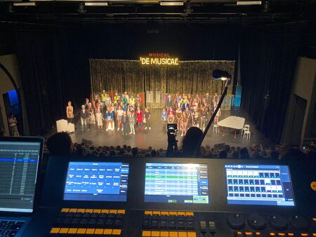 Een podium met een musicalcast, gefotografeerd vanuit de licht- en geluidsconsole.