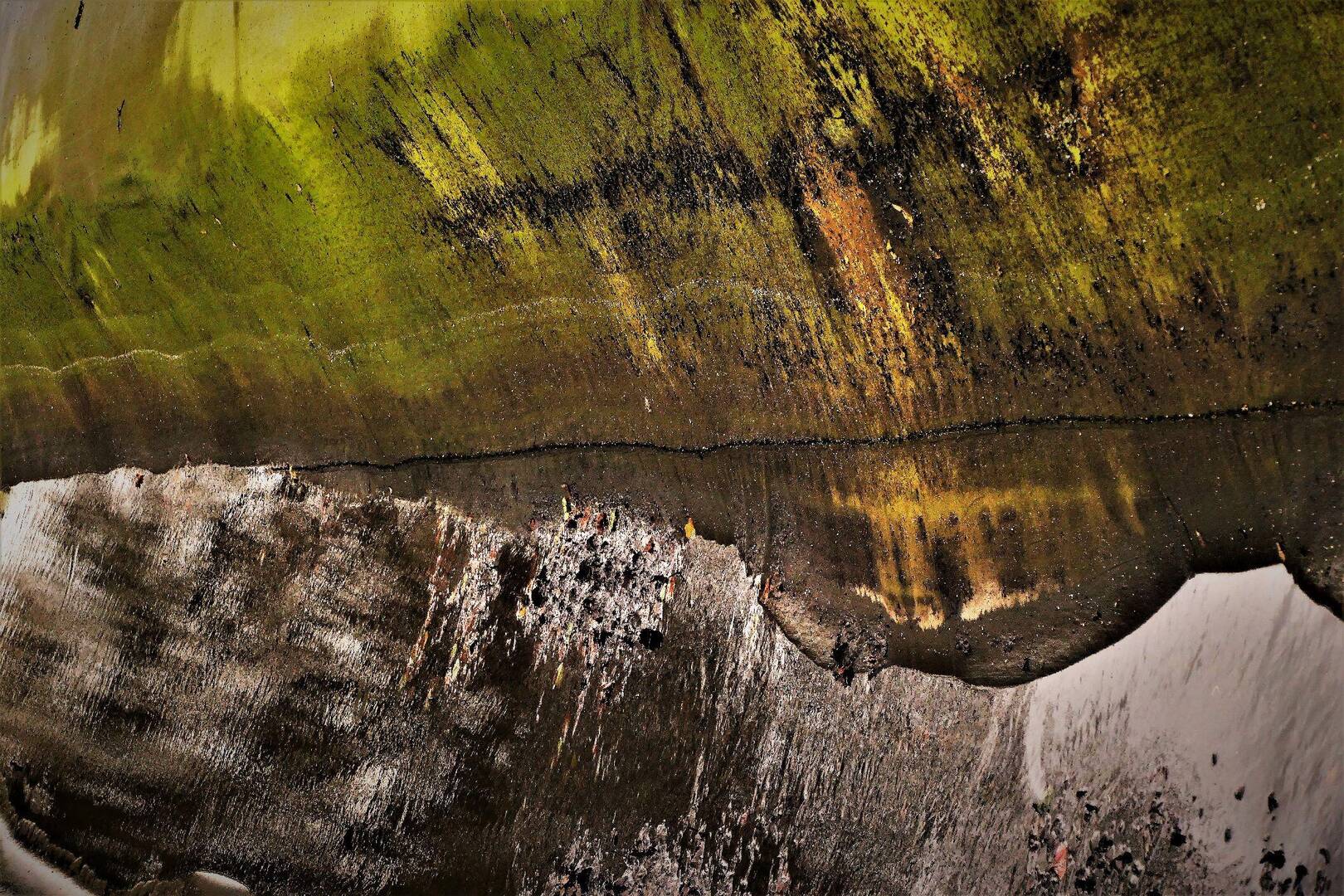 Abstracte afbeelding van een groene, verwerkte ondergrond met reflecties in een vochtige ondergrond.